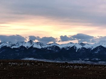 Scenic view of snowcapped mountains against sky during sunset