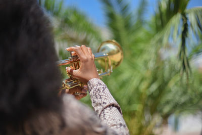 Midsection of woman playing with plant