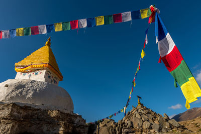 Low angle view of flags hanging against sky