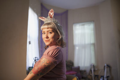 Young woman in front of mirror wearing bunny ears