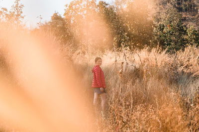 Rear view of woman walking on field