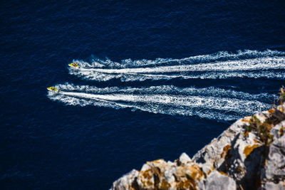 High angle view of vapor trails in sea