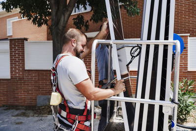 Technicians loading solar panels in hydraulic platform