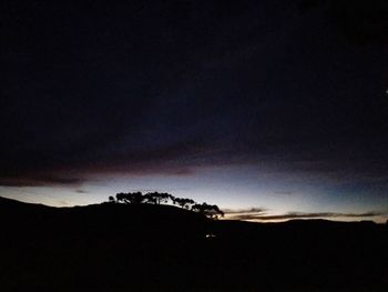 Silhouette landscape against sky at night