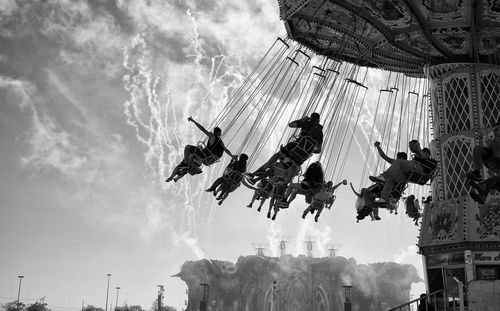 Low angle view of chain swing ride against sky