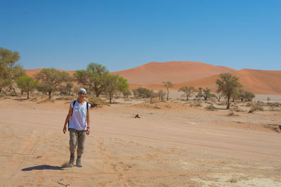 Tourist walking on sand at namib-naukluft national park