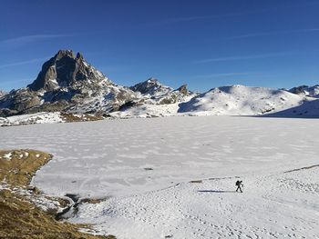 Scenic view of snowcapped mountains against blue sky