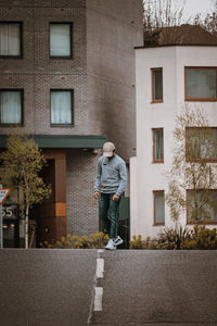 Full length of man walking on street against building