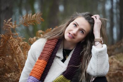 Portrait of young woman standing against plants