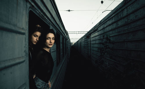 Portrait of young women peeking out from train window