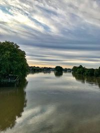 Scenic view of river against sky at sunset