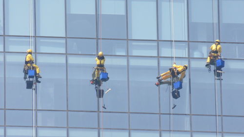 Low angle view of window washers cleaning office building