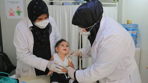 Female doctor examining patient in clinic