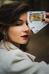 Close-up portrait of woman holding cards