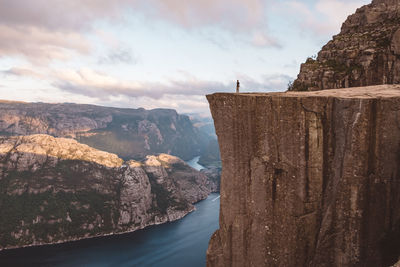 Man standing at edge of cliff at preikestolen, norway