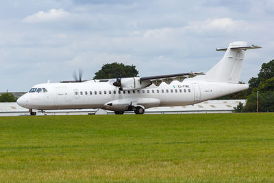 Side view of airplane on runway against sky