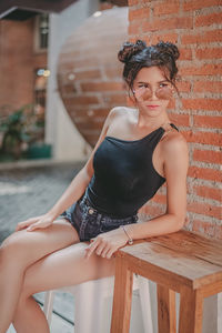 Portrait of woman sitting on wall