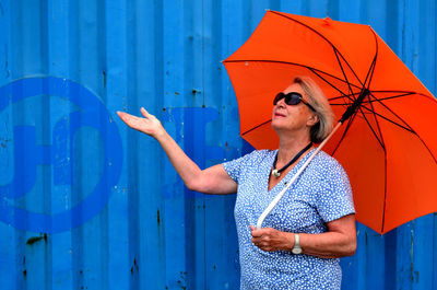 Full length of woman standing against blue wall