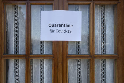 The sign quarantine for covid-19 virus in german language on a wooden window