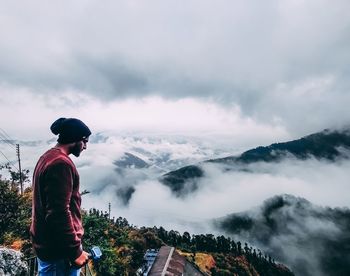 Man standing on mountain against sky