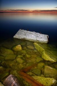 Close-up of rocks by sea against sky