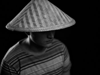 Portrait of boy wearing hat against black background