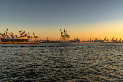 Pier over sea against clear sky during sunset