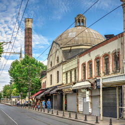 Group of people walking on road by building