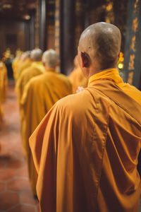 Rear view of monks standing at temple