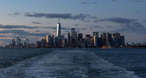 Lower manhattan skyline at sunset viewed from the water.