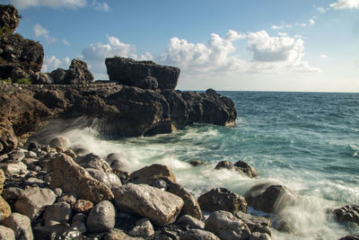 Scenic view of rocks in sea against sky