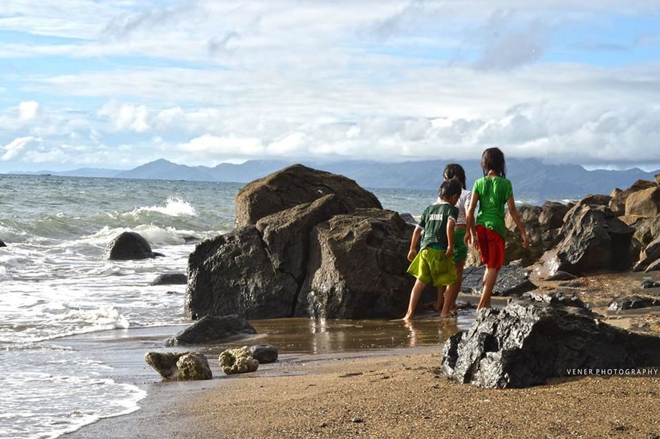 PANORAMIC VIEW OF PEOPLE STANDING AT BEACH AGAINST SKY