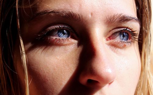 Close-up of thoughtful young woman with blue eyes