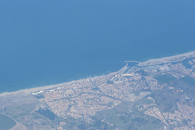 Aerial view of buildings in city against clear blue sky