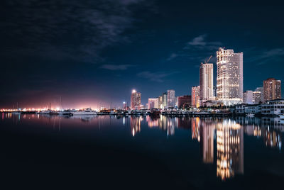 Reflection of illuminated buildings in city at night