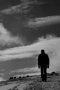 Rear view of silhouette man standing on land