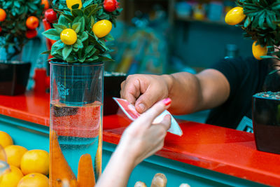 Cropped image of hand holding drink on table