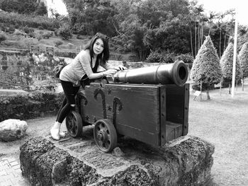 Portrait of young woman leaning on cannon