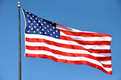 Low angle view of american flag against clear sky