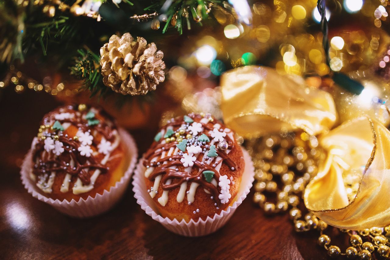 Close-up of sweet food by christmas tree on table