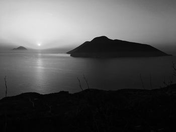 Scenic view of sea and mountains against clear sky