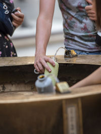 Midsection of woman filling bottle with water