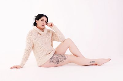 Portrait of woman sitting against white background