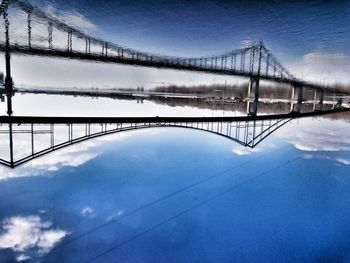 Bridge over river against sky during winter