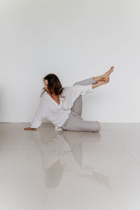 Portrait of young woman standing against white background