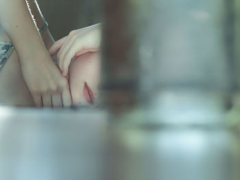 Midsection of woman relaxing on bed