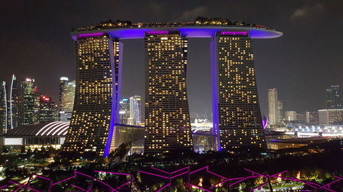 Illuminated cityscape against sky at night