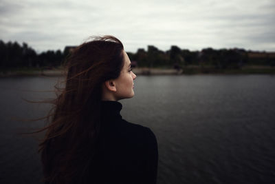 Side view of young woman looking at lake
