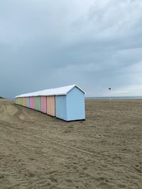 Hut on beach against sky