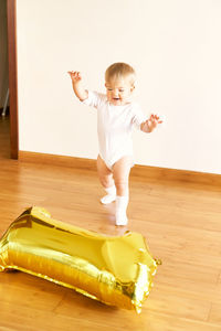 Full length of cute baby girl on hardwood floor